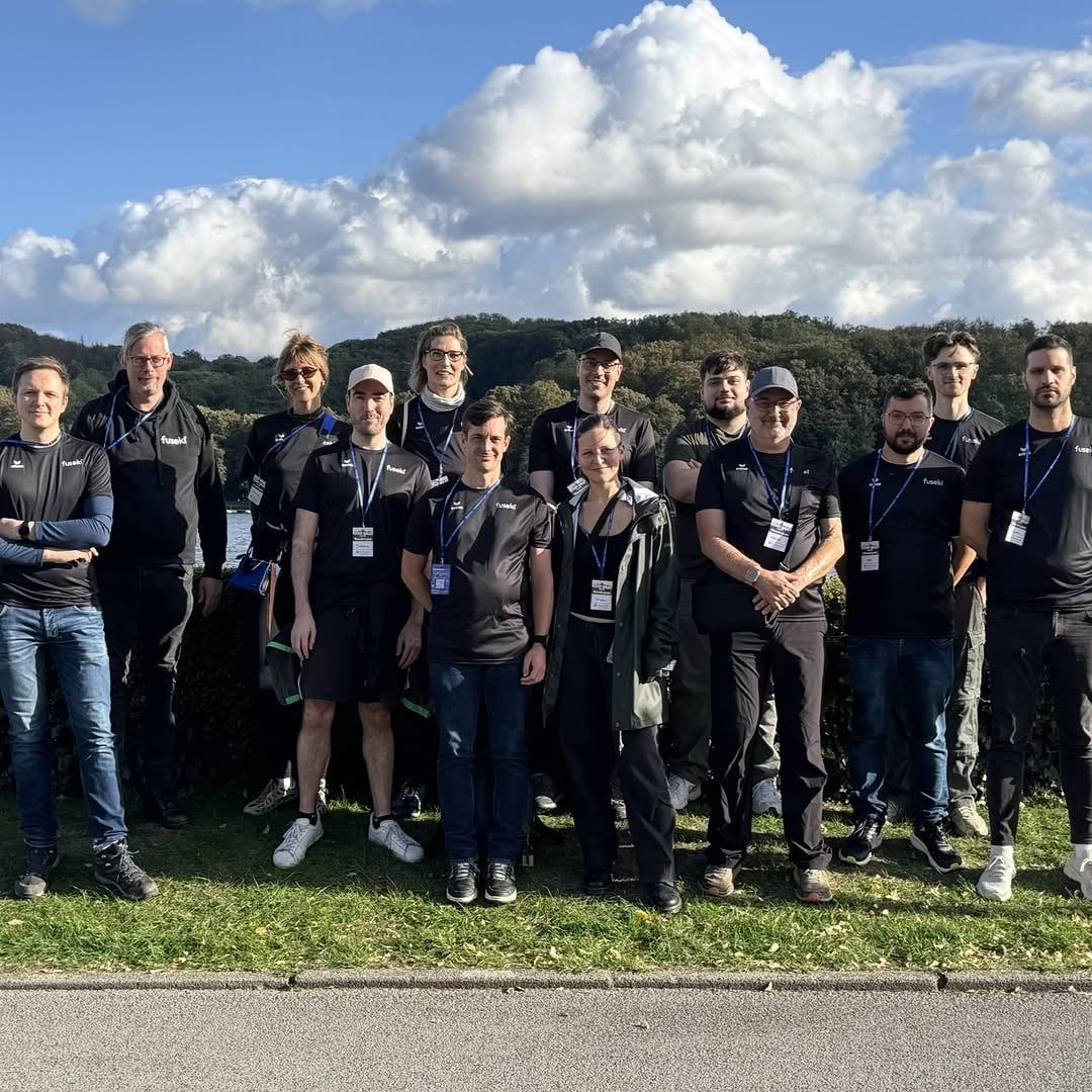 Gruppenfoto des Teams in Sportkleidung auf einer Wiese