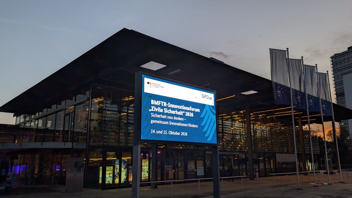 Tagungsgebäude am Abend mit Bildschirm-Aufsteller zum BMFTR-Innovationsforum „Zivile Sicherheit“ 2026